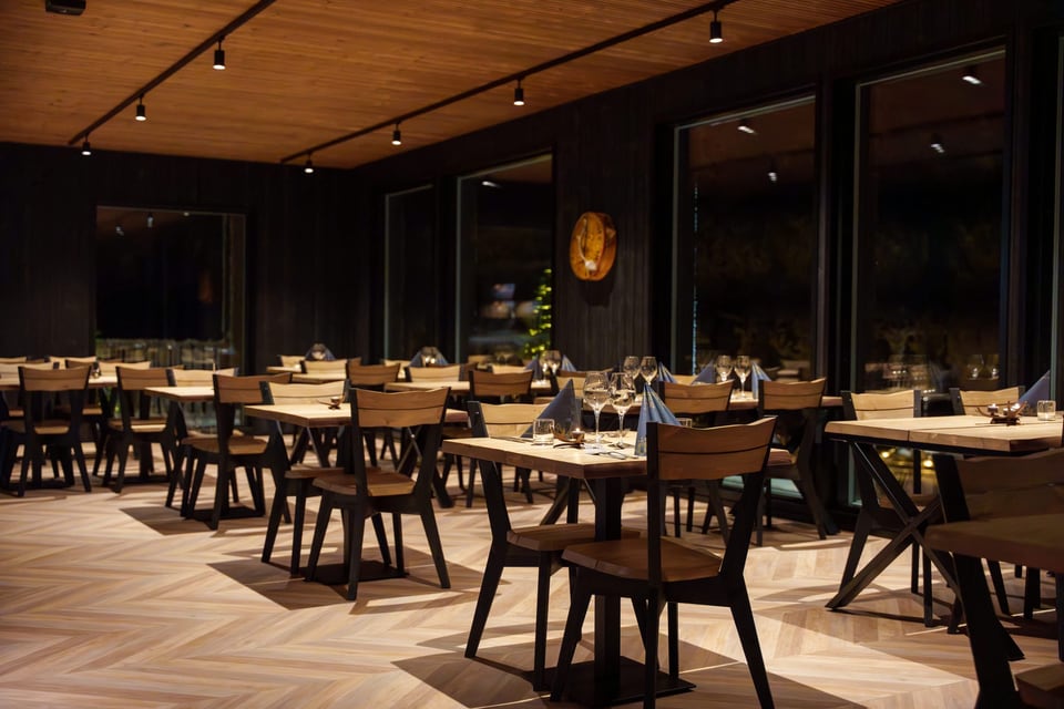The Bear restaurant at Arctic Lumo Resort, with tables set for dinner.